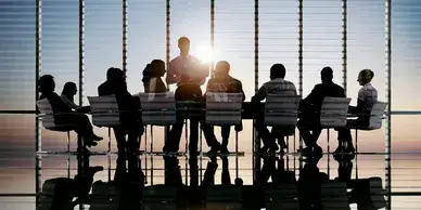 Colleagues in a business meeting with one presenter in a well lit conference room